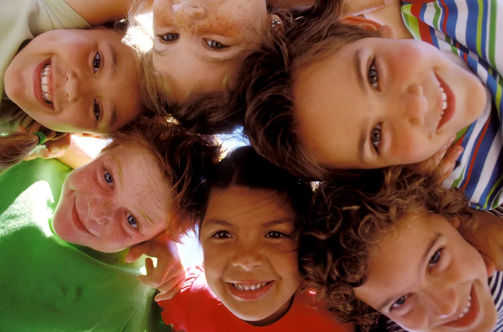 A group of children gathered in a circle, smiling