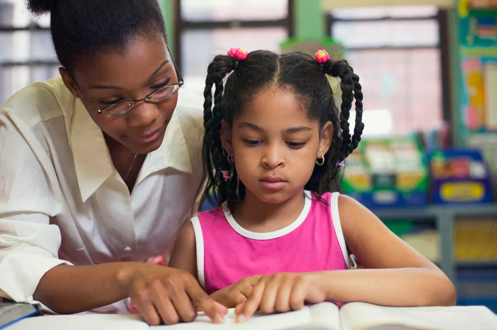 A young girl being helped with her homework